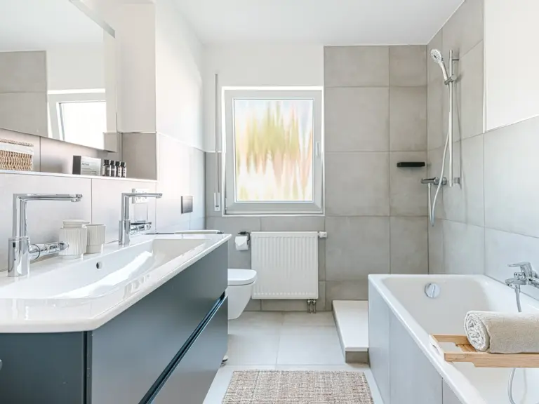 Bathroom in the Stay Eden MOONSTONE GREEN apartment in Ramstein, featuring both a modern walk-in shower and a comfortable bathtub.