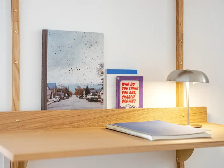Dedicated workspace in the Stay Eden MOONSTONE GREEN apartment in Ramstein, featuring a desk with soft, warm lighting for comfortable work.