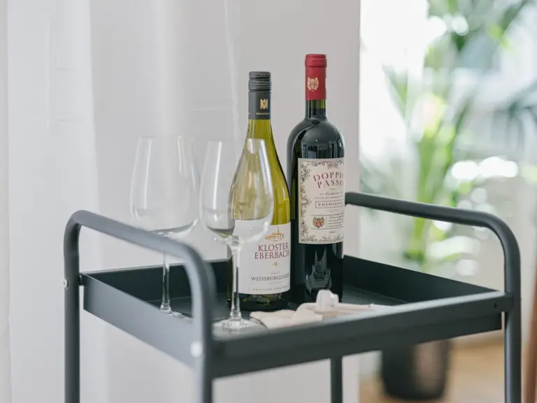 Dining area with wine bottles and modern decor at Stay Eden MOONSTONE GREEN, a Ramstein TDY apartment.