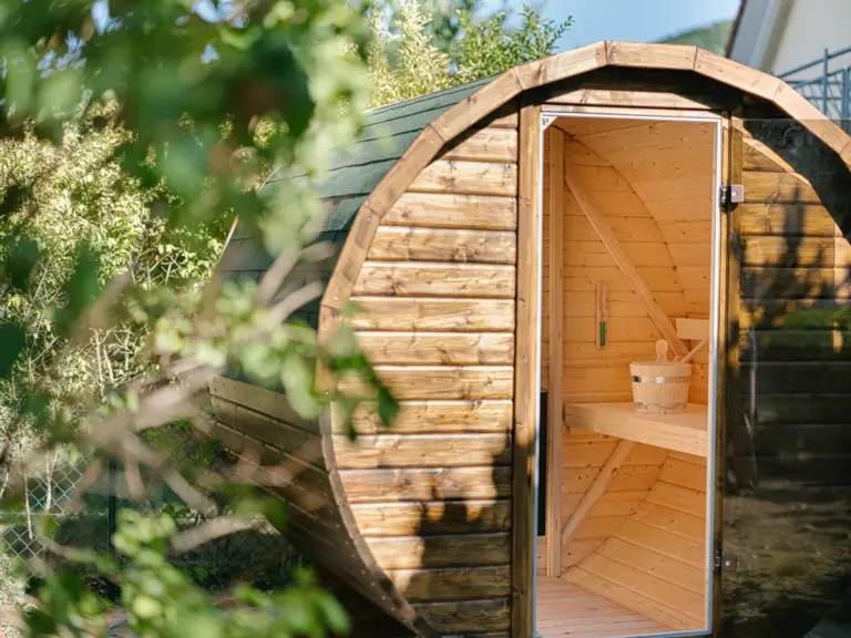 Outdoor Finnish sauna at the Stay Eden MOONSTONE GREEN apartment in Ramstein, placed in the garden area with wooden exterior.
