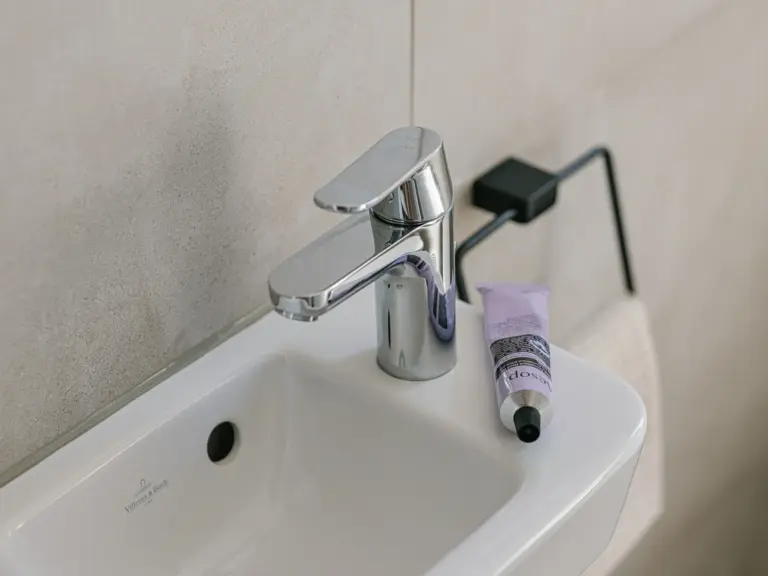 Half bath in the Stay Eden MOONSTONE GREEN apartment in Ramstein, featuring a modern wash basin and clean décor.