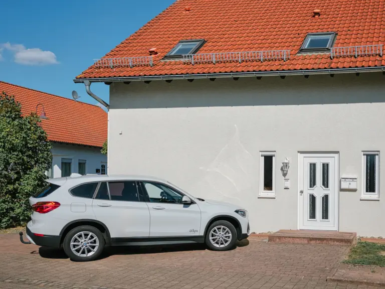Exterior view of the Stay Eden MOONSTONE GREEN apartment building in Ramstein, including the onsite parking area.