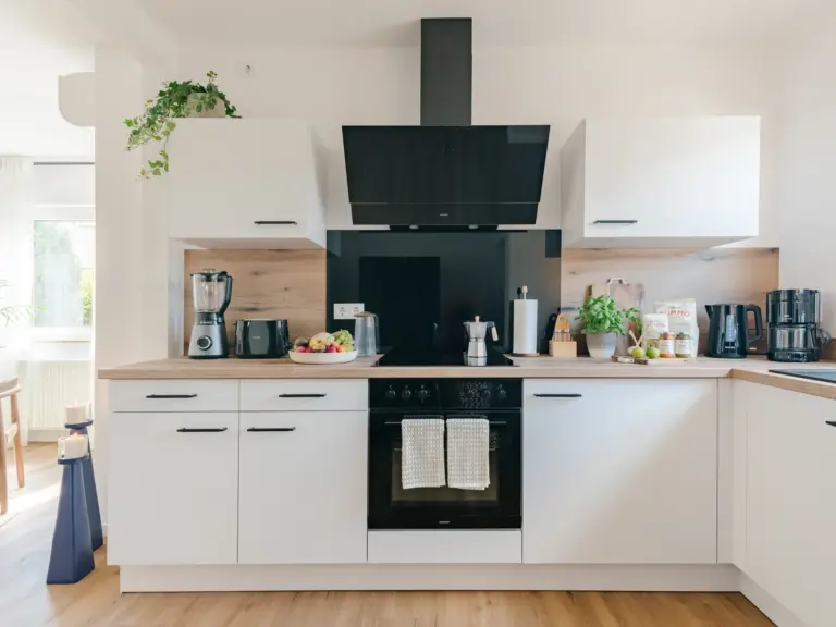 Modern kitchen with white cabinets and premium appliances at Stay Eden MOONSTONE GREEN, a Ramstein TLA apartment.