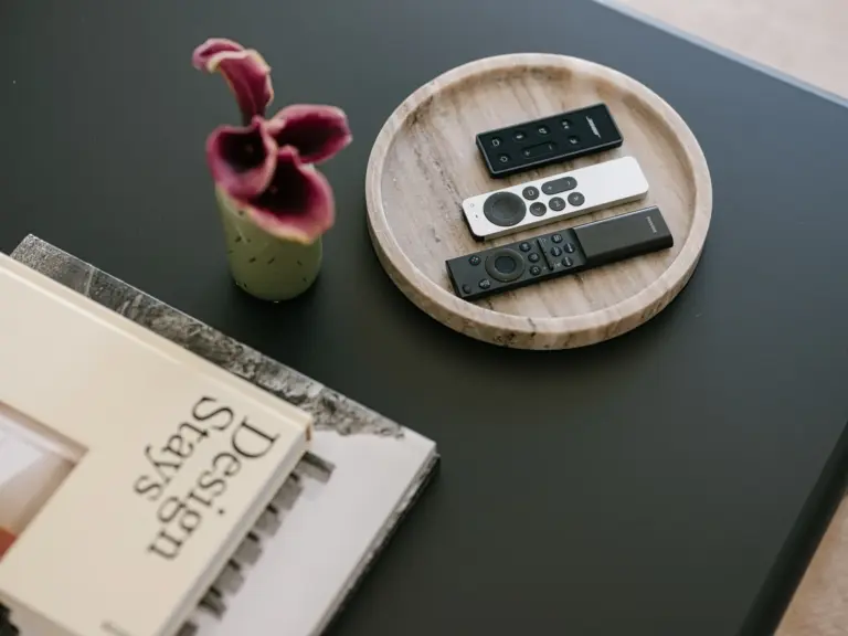 Apple TV and remote controls arranged in the living room of the Stay Eden MOONSTONE GREEN apartment in Ramstein, ready for guest use.