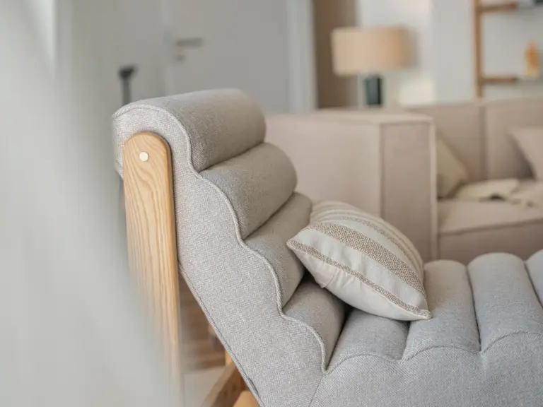 Modern chair in the living room of the Stay Eden MOONSTONE GREEN apartment in Ramstein, adding comfort and style to the space.