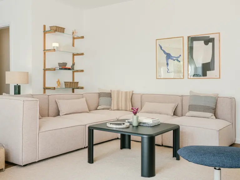 Cozy couch in the living room of the Stay Eden MOONSTONE GREEN apartment in Ramstein, styled with cushions and modern décor.