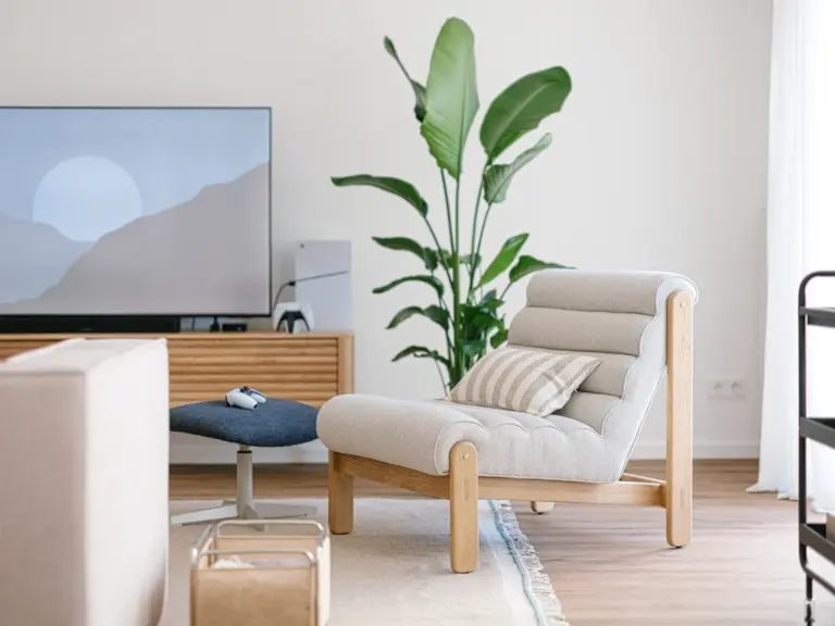 Lounge chair in the living room of the Stay Eden MOONSTONE GREEN apartment in Ramstein, positioned for comfort with modern décor around it.