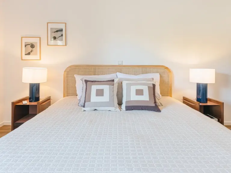 Master bedroom in the Stay Eden MOONSTONE GREEN apartment in Ramstein, featuring a modern king-size bed with cozy bedding and soft lighting.