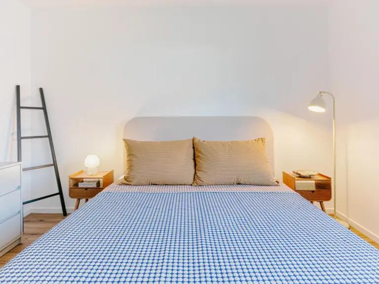 Second bedroom in the Stay Eden MOONSTONE GREEN apartment in Ramstein, featuring a comfortable queen-size bed with modern bedding.