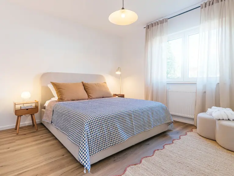 Second bedroom in the Stay Eden MOONSTONE GREEN apartment in Ramstein, featuring a queen-size bed, modern décor, and soft ambient lighting.