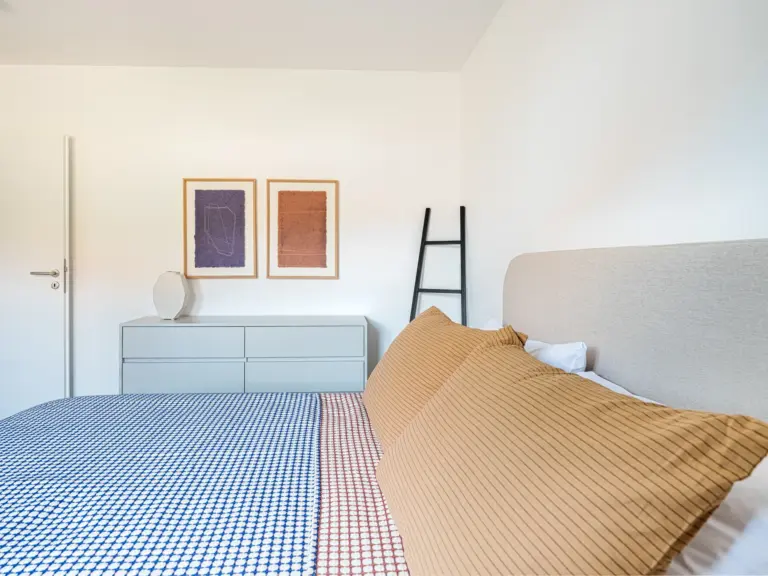 Second bedroom in the Stay Eden MOONSTONE GREEN apartment in Ramstein, featuring a modern sideboard for storage and décor.