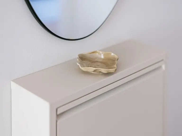 Entrance area wardrobe with mirror, coat hooks, shoe cabinet and seating stool at Stay Eden MOONSTONE GREEN Ramstein TLA apartment.