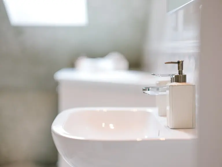 Bathroom wash basin with modern mirror and bright tiles at Stay Eden TOPAZ BLUE near Ramstein Air Base.