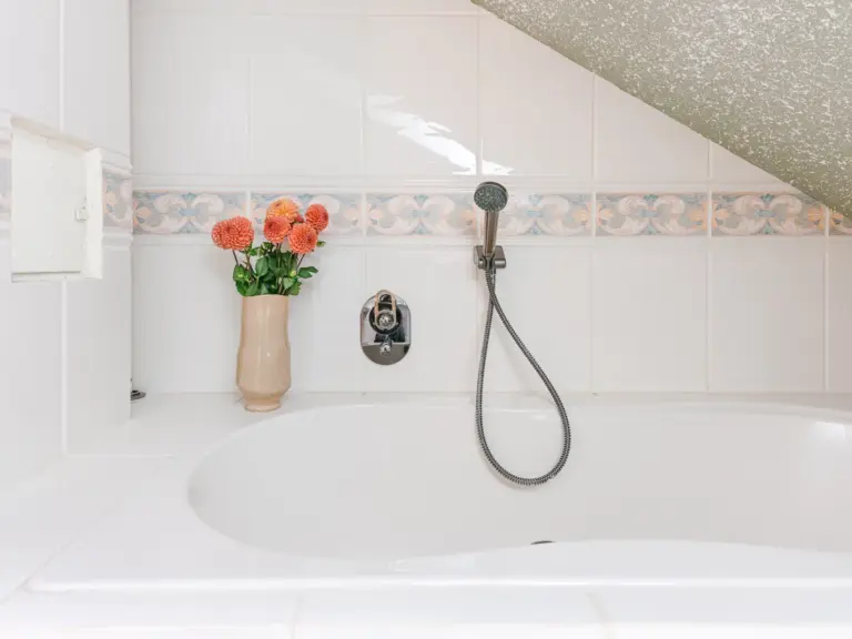 Bathroom with bathtub and clean tiles at Stay Eden TOPAZ BLUE near Ramstein Air Base.