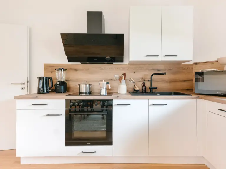 View of modern kitchen with clean white cabinetry at Stay Eden TOPAZ BLUE near Ramstein Air Base.