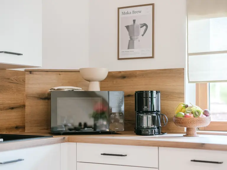 Kitchen with microwave, coffee machine and modern cabinetry at Stay Eden TOPAZ BLUE near Ramstein Air Base.