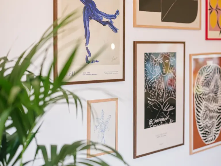 Living room with picture wall and decorative plant at Stay Eden TOPAZ BLUE near Ramstein Air Base.