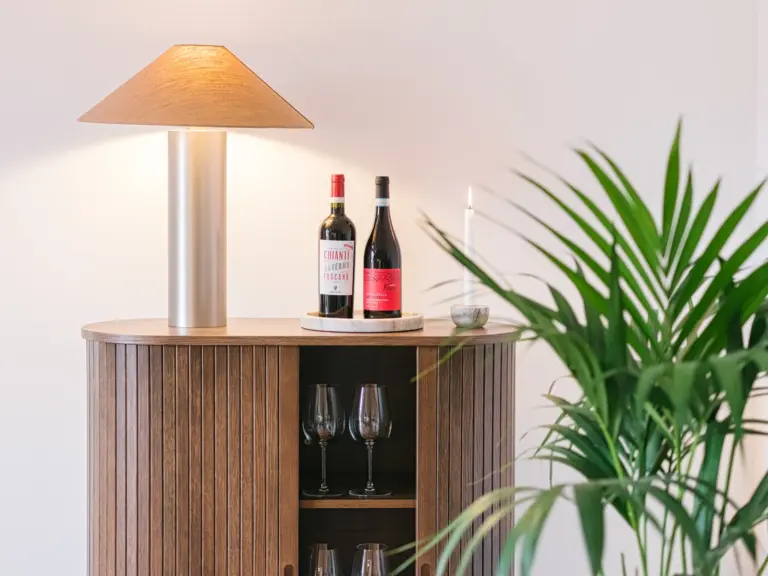 Living room sideboard with wine bottles and modern decor at Stay Eden TOPAZ BLUE near Ramstein Air Base.