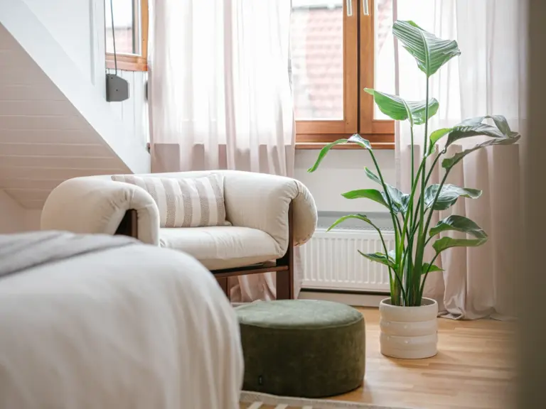 Master bedroom with cozy sitting area and king-size bed at Stay Eden TOPAZ BLUE near Ramstein Air Base.