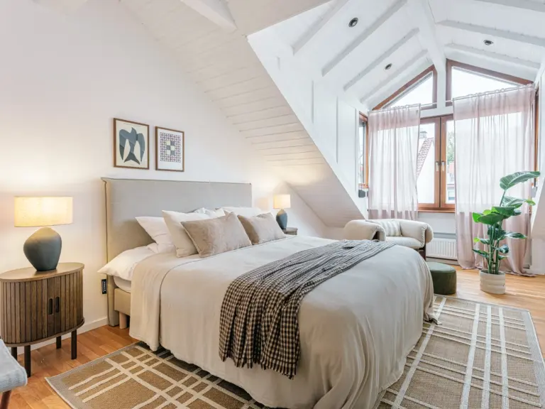 Master bedroom with king-size bed and warm lighting at Stay Eden TOPAZ BLUE near Ramstein Air Base.