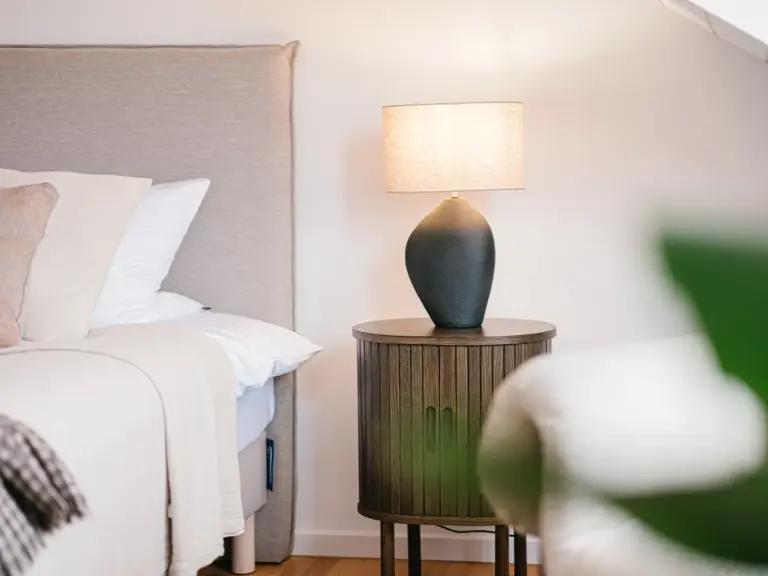 Master bedroom with stylish nightstand and king-size bed at Stay Eden TOPAZ BLUE near Ramstein Air Base.