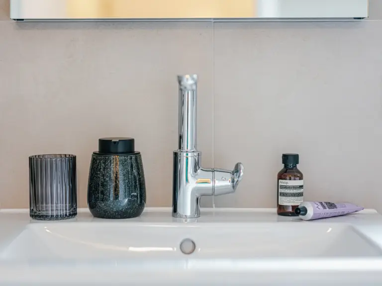 Modern wash basin with mirror and light tiles at Stay Eden TOPAZ GREEN near Ramstein Air Base.