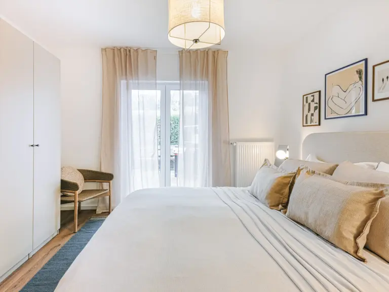 Main bedroom with king-size bed and modern decor at Stay Eden TOPAZ GREEN near Ramstein Air Base.