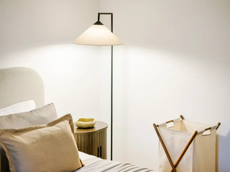 Master bedroom with king-size bed and laundry basket at Stay Eden TOPAZ GREEN near Ramstein Air Base.