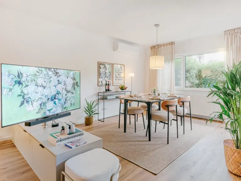 Modern dining area with elegant table and chairs, swivel Smart TV and warm lighting at Stay Eden TOPAZ GREEN apartment near Ramstein.