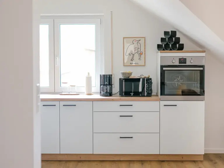 Bright, fully equipped kitchen in the Stay Eden SAPPHIRE BLUE apartment in Ramstein, featuring modern appliances and clean countertops.