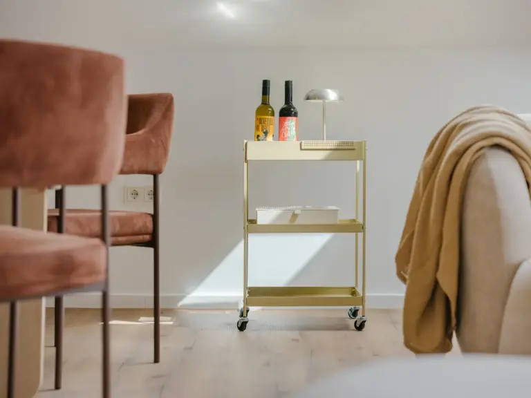 Dining area in the Stay Eden SAPPHIRE BLUE apartment in Ramstein, featuring modern décor with wine bottles arranged as decorative elements.