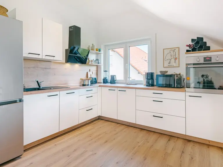 Fully equipped kitchen in the Stay Eden SAPPHIRE BLUE apartment in Ramstein, featuring modern appliances, clean countertops, and bright décor.