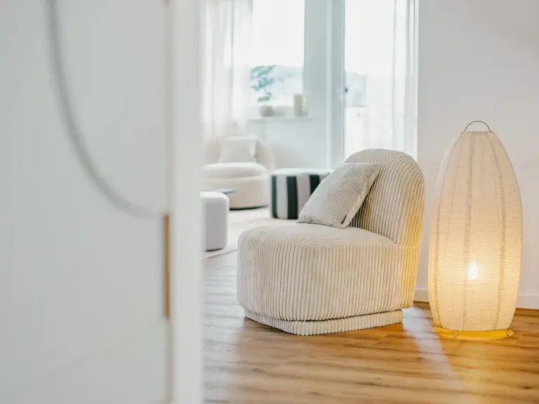 Living room in the Stay Eden SAPPHIRE BLUE apartment in Ramstein, featuring a comfortable modern lounge chair.