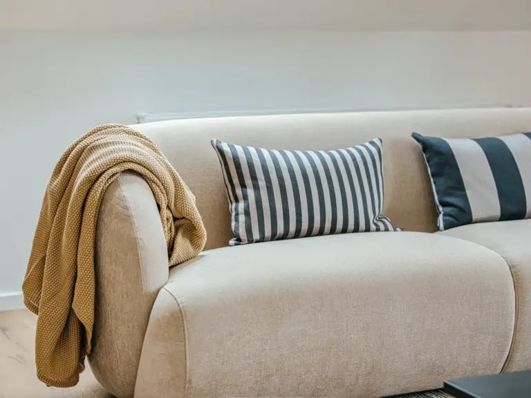 Living room in the Stay Eden SAPPHIRE BLUE apartment in Ramstein, featuring a modern couch and bright, cozy décor.