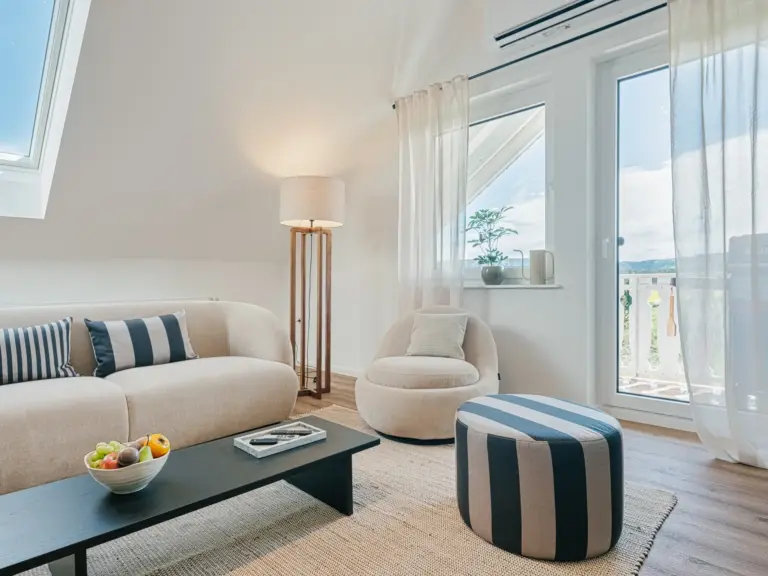 Living room in the Stay Eden SAPPHIRE BLUE apartment in Ramstein, featuring modern furnishings and direct access to a private balcony.