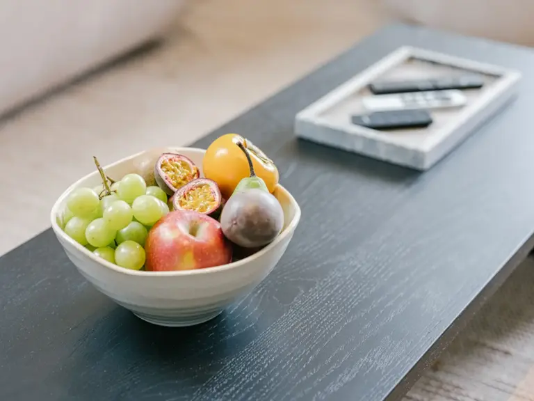 Living room in the Stay Eden SAPPHIRE BLUE apartment in Ramstein, featuring a decorative fruit basket on the coffee table.