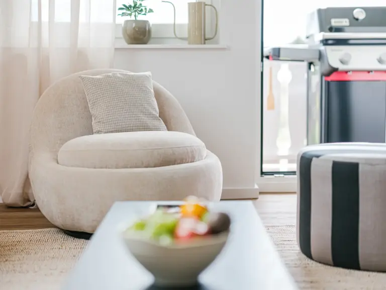 Living room in the Stay Eden SAPPHIRE BLUE apartment in Ramstein, featuring a cozy lounge chair and modern décor.