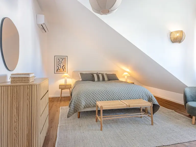 Master bedroom in the Stay Eden SAPPHIRE BLUE apartment in Ramstein, featuring a king-size bed, modern décor, and soft lighting.