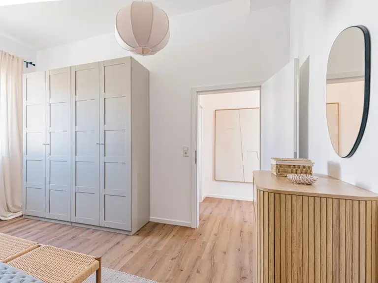 Master bedroom in the Stay Eden SAPPHIRE BLUE apartment in Ramstein, featuring a large, modern wardrobe with ample storage space.