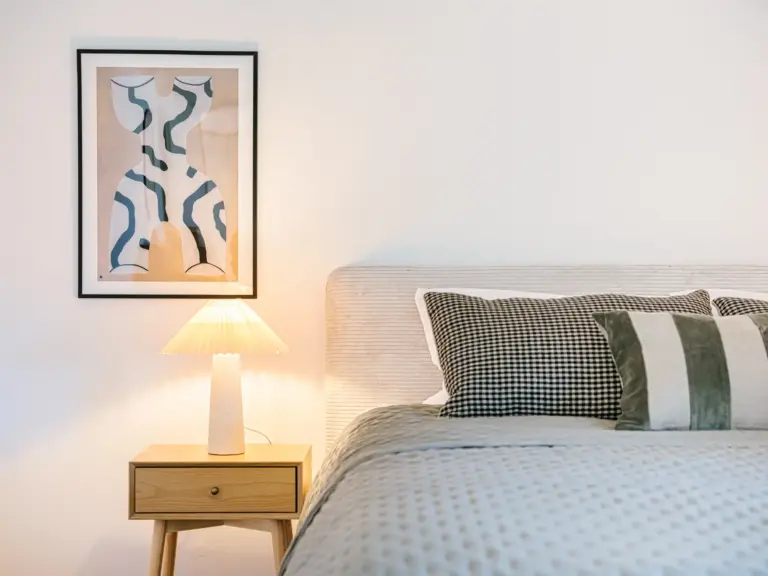 Master bedroom in the Stay Eden SAPPHIRE BLUE apartment in Ramstein, featuring stylish nightstands with modern décor on each side of the bed.