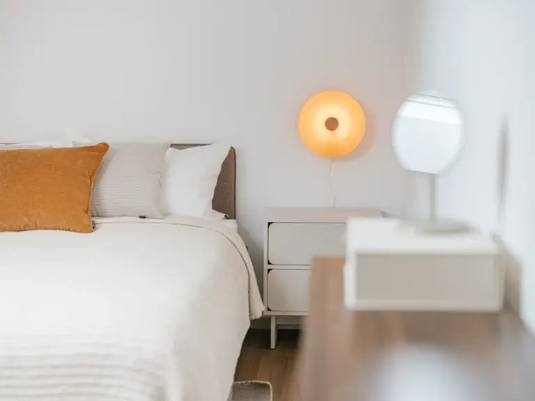 Second bedroom in the Stay Eden SAPPHIRE BLUE apartment in Ramstein, featuring a modern nightstand with a stylish lamp beside the bed.
